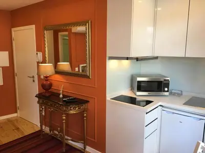 a small kitchen with a microwave and a sink at Casas do Loureiro in Porto