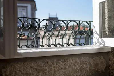 a balcony with a iron railing and a window at Casas do Loureiro in Porto