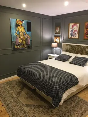 a bedroom with a bed and a painting on the wall at Casas do Loureiro in Porto