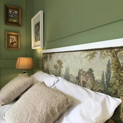 a bedroom with a bed with a painting on the wall at Casas do Loureiro in Porto