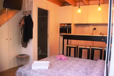 a room with a bed and a kitchen with a piano at Loft Mártires in Porto