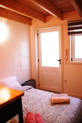 a bedroom with a bed with a window and a door at Loft Mártires in Porto