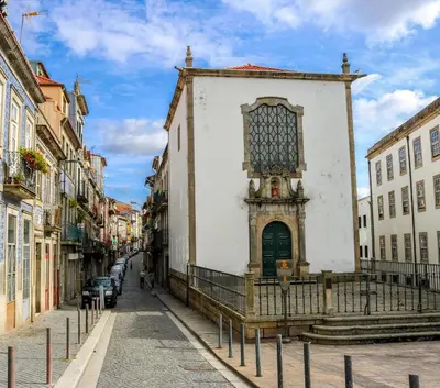 a white building with a window on a street at Bluetile Sol Apartment in Porto