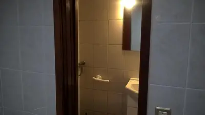 a bathroom with a toilet and a sink and a light at Silver Porto - AL in Porto
