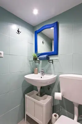 a bathroom with a sink and a mirror and a toilet at Oporto Blue Picaria - Unique Citycenter Apartment in Porto