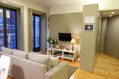a living room with a couch and a tv at Porto Tropical Charm in Porto