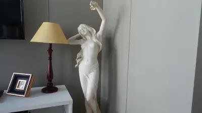 a statue of a woman standing on a table next to a lamp at Porto Tropical Charm in Porto