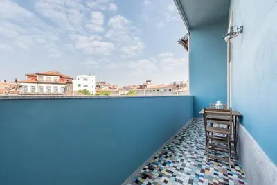 a room with a blue wall with a table and a window at GuestReady - Modern stay in downtown Porto in Porto