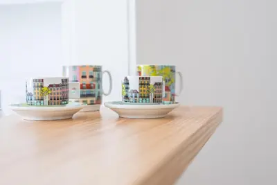 two coffee mugs sitting on top of a wooden table at GuestReady - Modern stay in downtown Porto in Porto