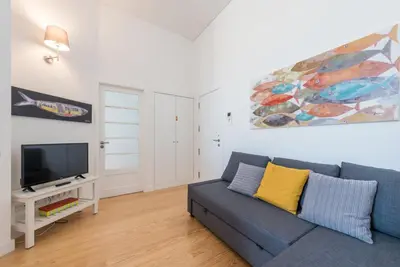 a living room with a blue couch and a tv at GuestReady - Modern stay in downtown Porto in Porto