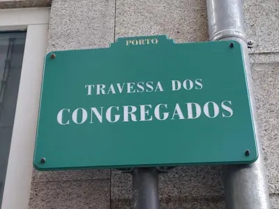 a green street sign in front of a building at ML Apartments Central Aliados in Porto
