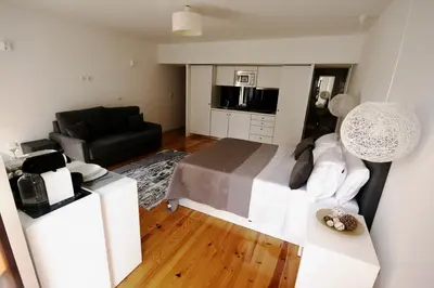 a bedroom with a bed and a living room at Invictus Place in Porto