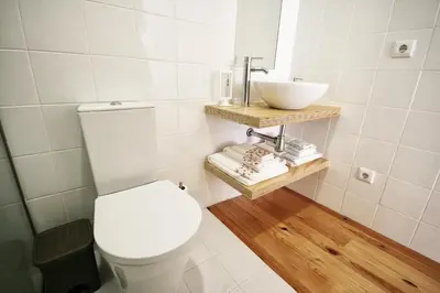 a bathroom with a white toilet and a sink at Invictus Place in Porto