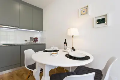 a white dining room with a white table and chairs at Porto Terrace Apartment in Porto