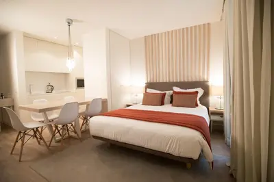 a bedroom with a large bed and a table and chairs at Almada Wine House - Tourism Apartments in Porto