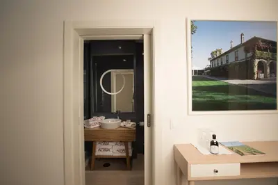 a door leading into a bathroom with a table and a sink at Almada Wine House - Tourism Apartments in Porto