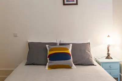 a bed with a colorful pillow on top of it at Home Alegria in Porto