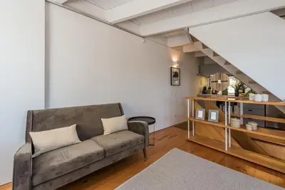 a living room with a couch and a staircase at Casa Dona Olga River View in Porto