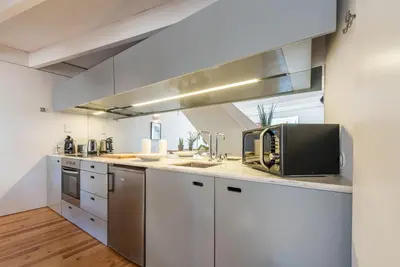a kitchen with white cabinets and stainless steel appliances at Casa Dona Olga River View in Porto