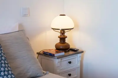 a lamp on a night stand next to a bed at Sunny Home in Porto