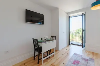 a dining room with a table and a tv on the wall at Sunny Home in Porto
