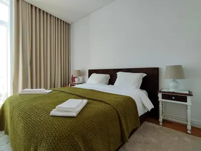 a bedroom with a large bed with a green blanket at Casa Velha Guesthouse in Porto