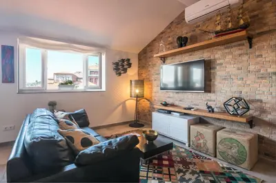 a living room with a leather couch and a brick wall at Merc Porto Ribeira's Up place in Porto