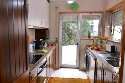 a kitchen with a sink and a sliding glass door at Apartamento Porto Centro in Porto