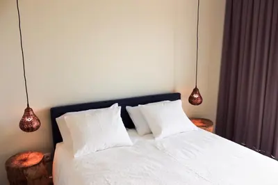 a bedroom with a bed with white sheets and two lamps at Apartamento da Lapa in Porto