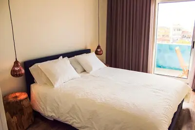 a bedroom with a white bed with a window at Apartamento da Lapa in Porto