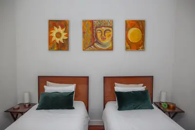 two beds in a room with paintings on the wall at Bonjardim Terrace in Porto