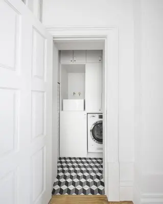 a white kitchen with a black and white checkered floor at BmyGuest - Porto Design Central Apartment in Porto