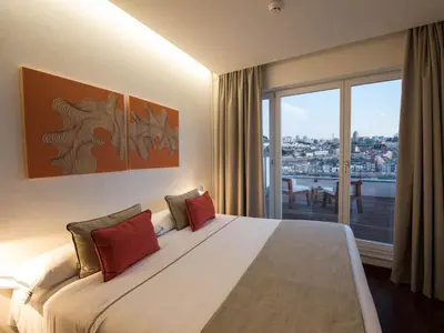 a bedroom with a bed and a flat screen tv at Hotel Carris Porto Ribeira in Porto