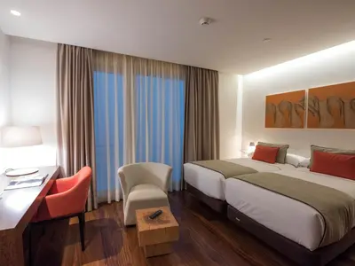 a bedroom with a large white bed and a window at Hotel Carris Porto Ribeira in Porto