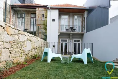 two chairs sitting in the grass in front of a house at Lovely Porto in Porto