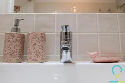 a kitchen counter with two rolls of paper towels and a faucet at Lovely Porto in Porto