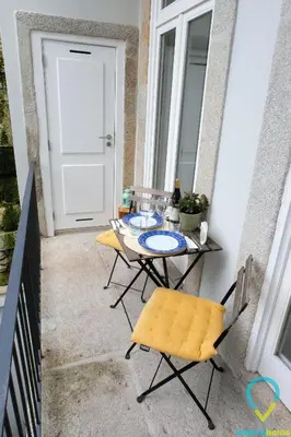 a table and chairs on a balcony with a door at Lovely Porto in Porto