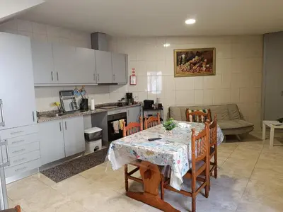 a kitchen and dining room with a table and chairs at Casinha Miradouro in Vila Nova de Gaia