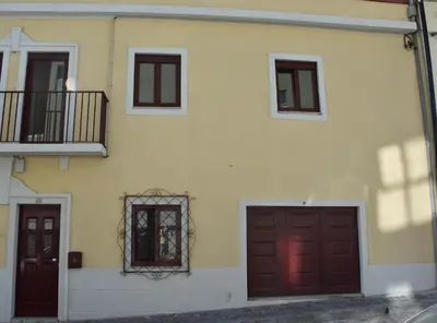 a building with two garage doors and a balcony at Casinha Miradouro in Vila Nova de Gaia
