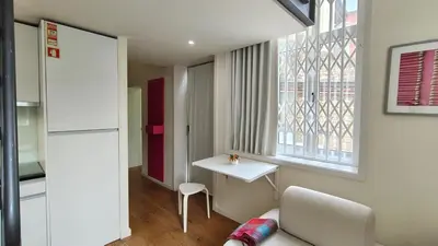 a white bedroom with a bed and a table at Domus 21 - Entreparedes in Porto