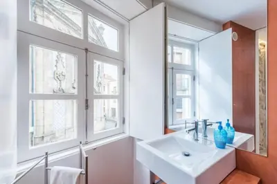 a bathroom with a sink and two windows at GuestReady - The New Yellow Ledbetter in Porto
