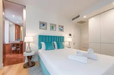 a bedroom with a large white bed with blue accents at GuestReady - The New Yellow Ledbetter in Porto
