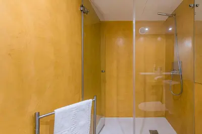 a shower with a glass door in a bathroom at GuestReady - The New Yellow Ledbetter in Porto