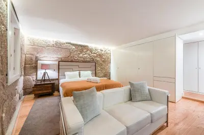 a bedroom with a bed and a white couch at GuestReady - The New Yellow Ledbetter in Porto