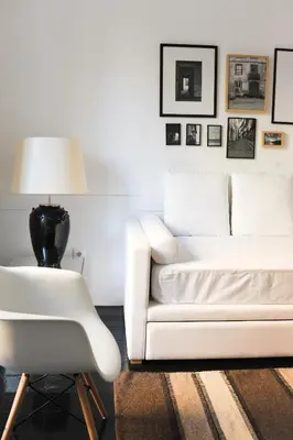 a living room with a white couch and a chair at Mo House in Porto