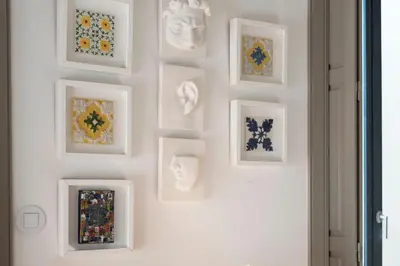 a wall with framed art on a white wall at Bom-Jardim Trindade in Porto