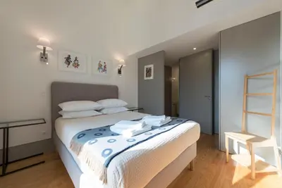 a bedroom with a large white bed with white pillows at Bom-Jardim Trindade in Porto