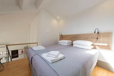 a bedroom with a bed with towels on it at Bom-Jardim Trindade in Porto