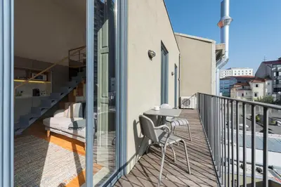 a balcony with a table and chairs on a building at Bom-Jardim Trindade in Porto