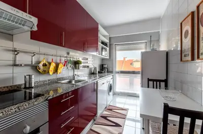a kitchen with red cabinets and a refrigerator at Porto Downtown Apartment in Porto